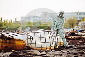 Man with gas mask and green military clothes explores barrels af