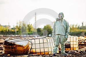 Man with gas mask and green military clothes explores barrels af