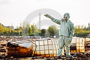 Man with gas mask and green military clothes explores barrels af
