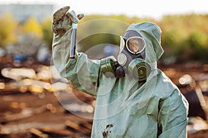 Man with gas mask and green military clothes explores barrels af