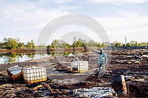 Man with gas mask and green military clothes explores barrels af