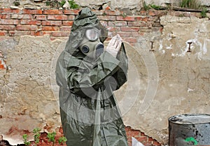 Man with gas mask and green military clothes explores small pl