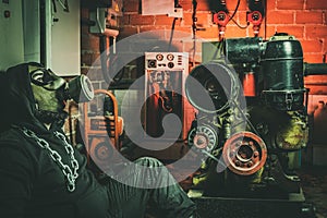 Man with gas mask and a hammer in machine room. Nuclear, Biological and Chemical danger concept