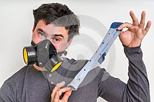 Man with gas mask is holding dirty stinky sock