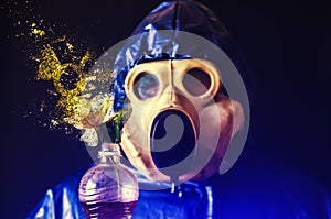 Man in the gas mask holding plastic bottle with flower falling into pieces. Radiation influence. Environmental pollution.