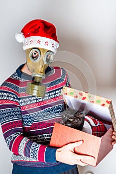 Man in gas mask introducing his new cat as a Christmas gift in package
