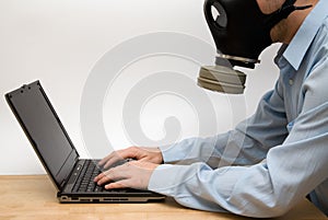 Man in gas mask and a laptop