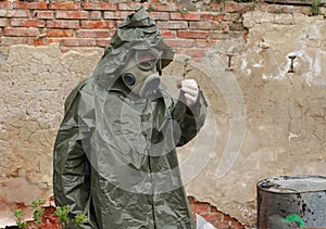 Man with gas mask and military clothes explores small plant