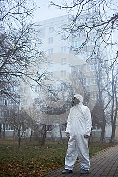 Man in gas mask and protective clothing outdoors.