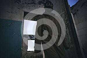 A man in gas mask walking inside an old building