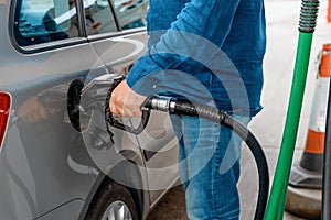 Man at the gas station filling the tank of his car with diesel to the top level before a long journey