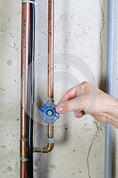 Man gently turning a valve on a water pipe