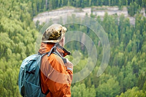 Man geologist against the backdrop of a wooded mountain landscape