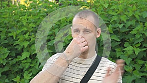 Man gestures a bad smell with his hand, closes his nose with his hands and acts nausea