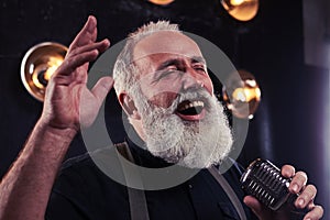 Man gesturing while accomplishing a jazz solo in a silver vintage microphone