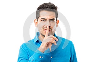 Man Gesturing Silence With Finger On His Lips