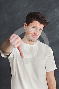 Man gesturing thumb up at gray background