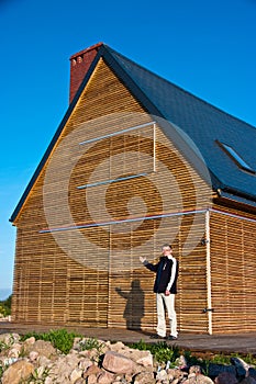 Man gesturing towards eco home