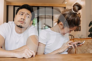 Muž dostane znuděný jako žena chatování na telefon dlouho. asijský v kavárna 