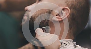 Man getting beard haircut by hairdresser