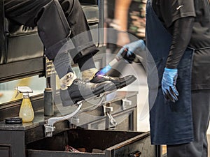 Man getting black shoes shined and finished with blow torch at station