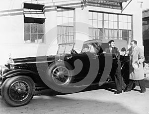 Man getting into car with chauffer