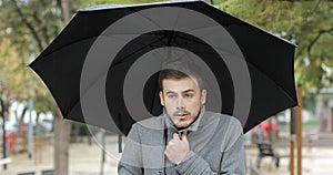 Man getting cold in a rainy day walking in a park