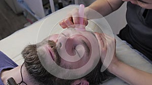 Man getting a face massage. beauty procedure, prevention of skin aging. vacuum massage using cups