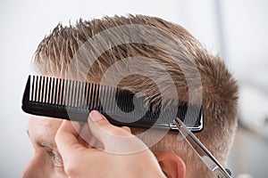 Man Getting Haircut From Hairdresser At Salon