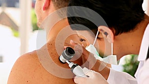 Man getting his mole checked by the dermatologist