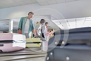 Man getting his suitcase on baggage claiming area in airport