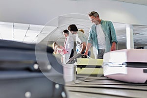 Man getting his suitcase on baggage claiming area in airport