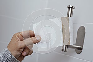 Man getting the last piece of toilet paper