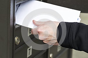 Man getting letters from postal mailbox