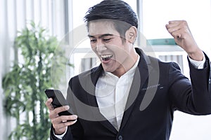 A man getting message in mobile phone and celebrate his success