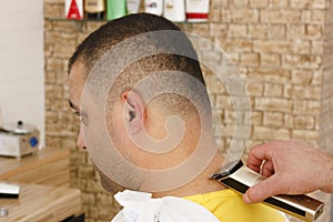 Man getting short hait trimming at a barber shop with clipper machine