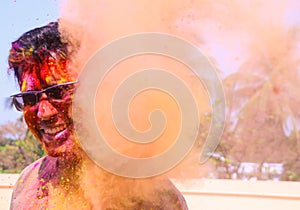 A man getting showered with holi colours during holi festival in india