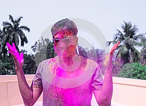 A man getting showered with holi colours during holi festival in india