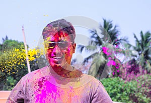 A man getting showered with holi colours during holi festival in india