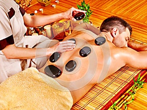 Man getting stone therapy massage .