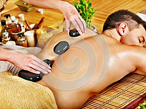 Man getting stone therapy massage .