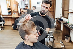 Man getting trendy haircut at barber shop.