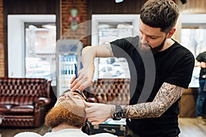 Man getting trendy haircut at barber shop.