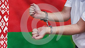 A man getting under arrest in Belarus. Concept of being handcuffed, detained, incarcerated and jailed in said country. National