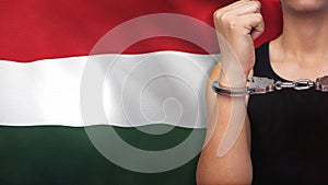 A man getting under arrest in Hungary. Concept of being handcuffed, detained, incarcerated and jailed in said country. National