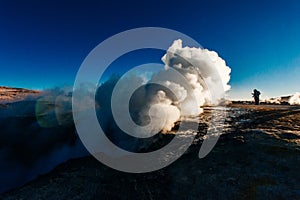 A man in the geysers at bolivian highlands Sol de la Manana, Uyuni Desert - december, 2018 photo