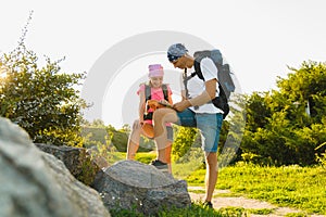 Man and girl with backpack resting and looking at map