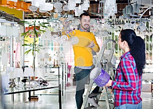 Man and girl choosing modern chandelier