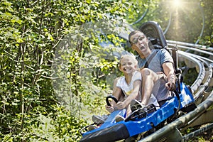 Man and girl enjoying a summer fun roller coaster ride