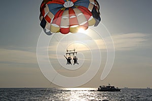 A man and a girl are flying on a parachute